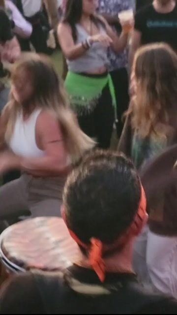 Drum circle with clothed crowd dancing