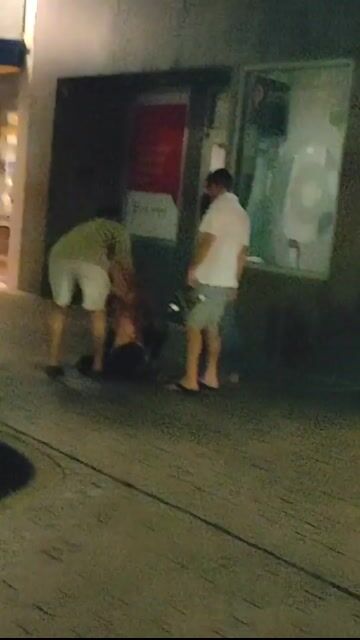Night street group outside store, clothed; dark but verifiable