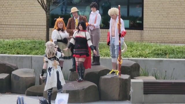 Cosplayers dancing in plaza, fully clothed
