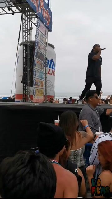 Clothed stage dancers and beach crowd