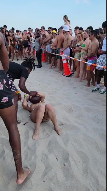Beach game with crowd in normal swimwear; context