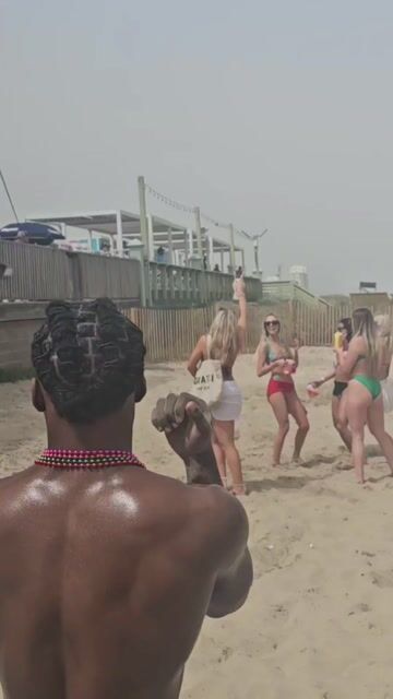 Women in bikinis on beach socializing, normal context