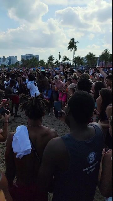 Large beach crowd in normal swimwear; context