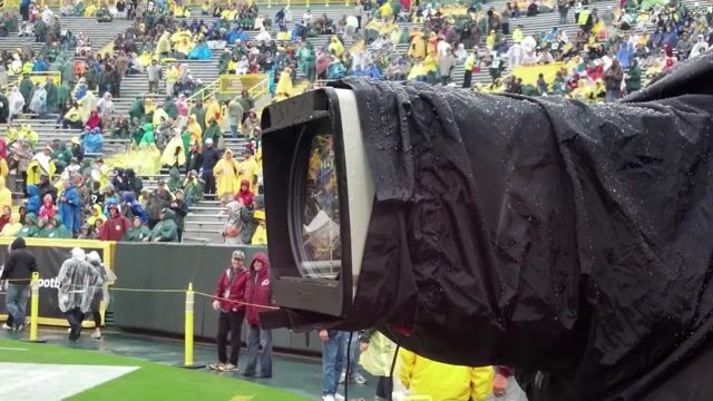 A television camera with the Klear Shot lens cleaning system in a football stadium on a rainy day