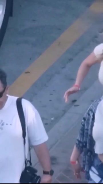 Two women walking, white tops + shorts, fully clothed