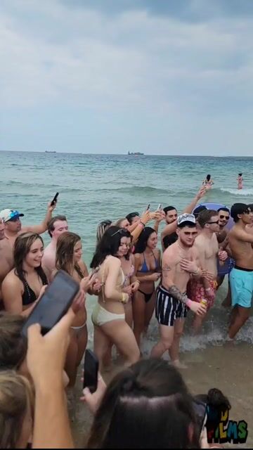 Large beach crowd in swimwear, no sexualized close-ups